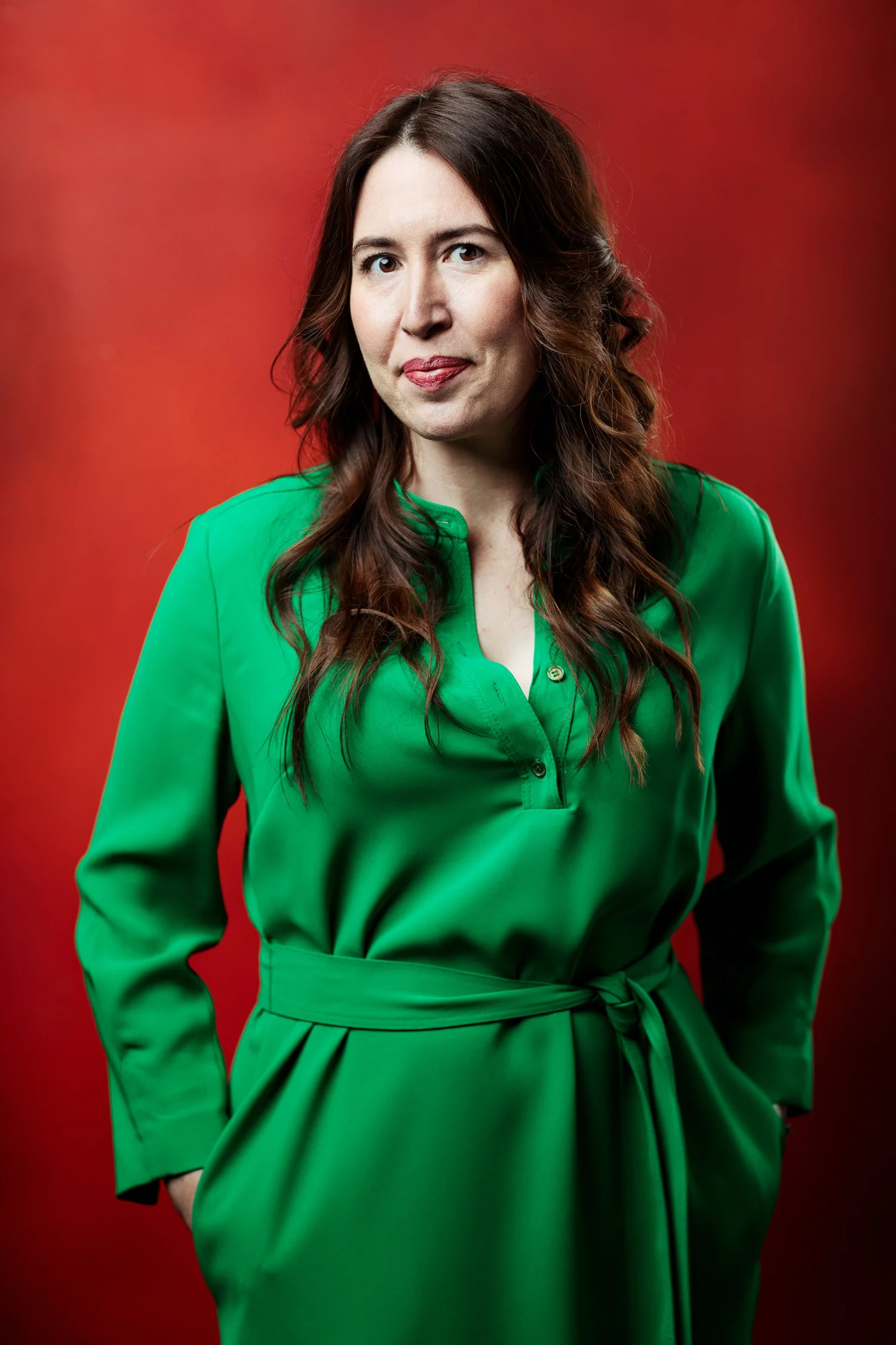 Emily Hunt-Adiletta wearing a bright green dress against a red background